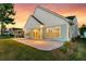 Exterior home shot at sunset highlighting the patio, lawn, and neighboring homes at 327 Tupelo Lake Dr, Summerville, SC 29486