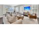 Bright living room boasts large picture windows with water views, stylish furniture, and hardwood floors at 327 Tupelo Lake Dr, Summerville, SC 29486