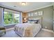 Relaxing bedroom with a large window, neutral tones, a comfortable bed, and elegant botanical wall art at 3307 Sawlog Dr, Summerville, SC 29486