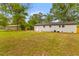 Large backyard features green grass, a fence, and mature trees with the back of the house at 346 Horseshoe Rd, Moncks Corner, SC 29461