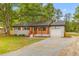 Inviting one-story home boasts a brick exterior, a wooden porch, and a spacious gravel driveway at 346 Horseshoe Rd, Moncks Corner, SC 29461