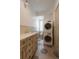 Bathroom features double sinks, tile floors, a toilet, and a stacked washer/dryer at 35 Society # H, Charleston, SC 29401