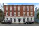 Charming exterior view of a multi-story brick building with symmetrically placed windows and two cars in front at 35 Society # H, Charleston, SC 29401