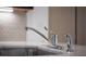 Close-up shot of a modern kitchen sink with a sleek faucet and marble countertop with matching backsplash at 35 Society # H, Charleston, SC 29401