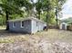 Spacious backyard featuring a gray brick home, ample green space, a storage shed, and mature trees at 354 Deloach Ave, Walterboro, SC 29488