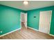 Bright bedroom with aqua walls, light hardwood floors, and white doors at 354 Deloach Ave, Walterboro, SC 29488