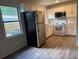 Well-lit kitchen featuring white cabinets, modern appliances, updated flooring, and plenty of counter space at 354 Deloach Ave, Walterboro, SC 29488