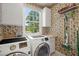 Functional laundry room with washer and dryer, storage, and a window for natural light at 3756 Colonel Vanderhorst Circle, Mount Pleasant, SC 29466