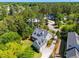 Aerial view of a well-landscaped home with inviting porch and a spacious garage nestled among mature trees in a serene neighborhood at 380 Tidal Reef Cir, Mount Pleasant, SC 29464