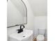 Well-lit bathroom featuring a black faucet, white sink, and an arched mirror at 380 Tidal Reef Cir, Mount Pleasant, SC 29464