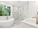 Bright bathroom featuring a modern tub, glass shower, and a marble-topped vanity at 380 Tidal Reef Cir, Mount Pleasant, SC 29464