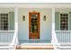 Close-up of a charming home's inviting front entrance, featuring a natural wood door and stylish outdoor lighting at 380 Tidal Reef Cir, Mount Pleasant, SC 29464