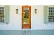 Close-up of a charming home's inviting front entrance, featuring a natural wood door and stylish outdoor lighting at 380 Tidal Reef Cir, Mount Pleasant, SC 29464