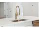 Close-up of kitchen island with gold faucet, quartz countertop, and stainless steel sink at 380 Tidal Reef Cir, Mount Pleasant, SC 29464