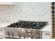 Stainless steel stove with a mosaic tile backsplash in a bright, modern kitchen at 380 Tidal Reef Cir, Mount Pleasant, SC 29464