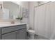 Well-lit bathroom features a vanity with gray cabinets and a white countertop, complemented by coastal-themed artwork at 403 Cool Bend Ln, Summerville, SC 29486
