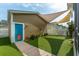 Exterior shot of the backyard shows artificial turf, a colorful door, and a shade sail at 422 Verbena Ave, Summerville, SC 29483