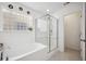 Bright bathroom features a soaking tub, a glass-enclosed shower, and a window for natural light at 422 Verbena Ave, Summerville, SC 29483