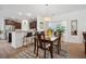 Dining area with wood table, chandelier, and adjacent breakfast bar and kitchen at 422 Verbena Ave, Summerville, SC 29483