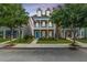 Charming two-story home featuring a welcoming front porch, colorful flower beds, and an American flag waving proudly at 422 Verbena Ave, Summerville, SC 29483