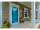 Cozy front porch featuring a turquoise door, decorative wreath, and comfortable seating area at 422 Verbena Ave, Summerville, SC 29483