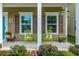 Relaxing front porch featuring comfortable seating, decorative pillows, and colorful potted plants at 422 Verbena Ave, Summerville, SC 29483