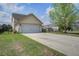 Two-car garage with long driveway and a well maintained lawn at 4303 Misty Hollow Ln, Ravenel, SC 29470