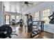 Bright gym with exercise equipment, hardwood floors, natural light, ceiling fans, and easy access to the pool at 4303 Misty Hollow Ln, Ravenel, SC 29470