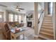 Inviting living room with a cozy fireplace, ceiling fan, plush couch and staircase at 4303 Misty Hollow Ln, Ravenel, SC 29470