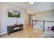 Upstairs loft featuring hardwood floors, a TV, and a staircase at 4303 Misty Hollow Ln, Ravenel, SC 29470
