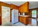 A kitchen with wood cabinets, white appliances, and a view into another room, possibly a dining area at 4327 Bream Rd, North Charleston, SC 29418