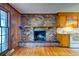 Living room with hardwood floors, brick fireplace, wood paneled walls and natural light from nearby windows at 4327 Bream Rd, North Charleston, SC 29418