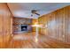 Spacious living room with hardwood floors, brick fireplace, and wood-paneled walls, adjacent to the kitchen at 4327 Bream Rd, North Charleston, SC 29418