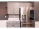 Close-up of the kitchen with gray cabinets, stainless steel fridge, and a modern backsplash at 4916 Paddy Field Way, Ladson, SC 29456