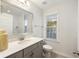 Bright bathroom featuring a large mirror, vanity with storage, quartz countertop, and a window with natural light at 555 Dunswell Dr, Summerville, SC 29486