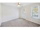 Bright bedroom with plush carpet, ceiling fan, and access door to outdoor area and natural light streaming from the window at 555 Dunswell Dr, Summerville, SC 29486