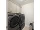 Laundry room with modern, gray front-loading LG washer and dryer set and built-in cabinets for efficient storage at 555 Dunswell Dr, Summerville, SC 29486