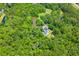 Lush, tree-filled property featuring a home with solar panels and a small pond at 6035 Bay Pond Rd, Ravenel, SC 29470