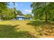 Large backyard with a screened porch, trees, and parking at 6035 Bay Pond Rd, Ravenel, SC 29470