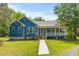 Well-maintained blue home with a welcoming front porch, showcasing a blend of comfort and classic design at 6035 Bay Pond Rd, Ravenel, SC 29470