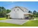 A charming two-story white home with a spacious porch, garage, and a gravel driveway, perfect for a serene retreat at 795 Shagule Rd, Edisto Island, SC 29438