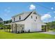 A stylish two-story white home featuring a covered porch and garage, complemented by lush greenery and a peaceful setting at 795 Shagule Rd, Edisto Island, SC 29438