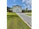Well-maintained home with a long gravel driveway, showcasing its modern design and landscaping at 795 Shagule Rd, Edisto Island, SC 29438
