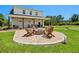 Inviting outdoor fire pit area with Adirondack chairs on a paver patio with a putting green near the home at 795 Shagule Rd, Edisto Island, SC 29438