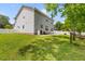 Expansive backyard view with a well-kept lawn, patio, and enclosed sunroom, showcasing the property's exterior at 828 Williamsburg Ln, Charleston, SC 29414