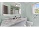 Bathroom featuring a marble vanity with black hardware, large mirror and a window at 828 Williamsburg Ln, Charleston, SC 29414