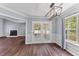 Bright dining room boasts hardwood floors, stylish lighting, and access to a sunroom at 828 Williamsburg Ln, Charleston, SC 29414