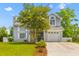 Lovely two-story home with a one-car garage, bright yellow front door and manicured landscaping at 828 Williamsburg Ln, Charleston, SC 29414