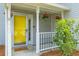 Inviting front porch with a bright yellow door, welcome mat, and hanging flower baskets at 828 Williamsburg Ln, Charleston, SC 29414