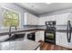 Functional kitchen with white cabinets and black appliances, well lit with natural light at 828 Williamsburg Ln, Charleston, SC 29414